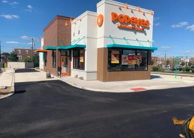 A newly paved drive-thru at a Popeyes Louisiana Kitchen restaurant in New Jersey, completed by Asphalt Worxx LLC, gleams under a clear blue sky.